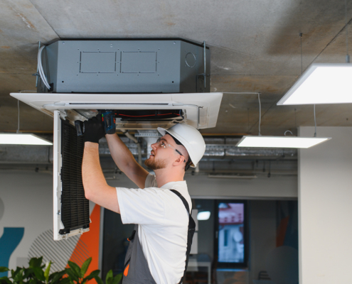 Hvac Technician Repairing Ceiling Air Conditioning System